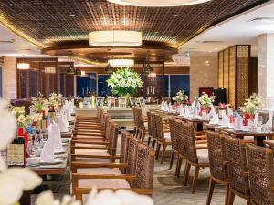 a banquet hall with tables and chairs and flowers at Sai Gon Ha Long Hotel in Ha Long