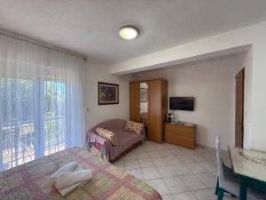 a hotel room with two beds and a television at Apartments Marina in Sukošan