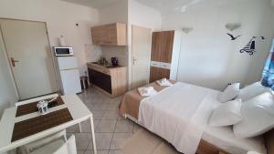 a small bedroom with a white bed and a kitchen at Budget Holiday Apartments Primorska in Pag