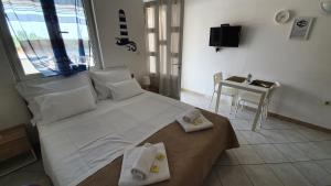 a bedroom with a large white bed with towels on it at Budget Holiday Apartments Primorska in Pag