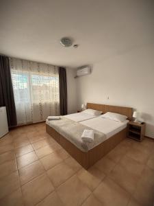 a bedroom with a large bed and a large window at Casa Silvia in Costinesti