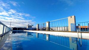 a pool of blue water in front of a building at Reinastays in Kiambu