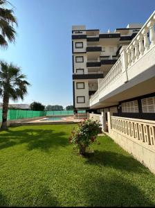 a building with a yard with a plant in the grass at Apartamento Piles playa in Piles