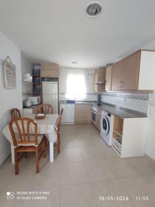 a kitchen with a table and chairs and a microwave at Apartamento Piles playa in Piles