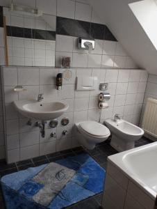a bathroom with a toilet and a sink at Hotel Al Cavallino in Arnstorf +34 photos