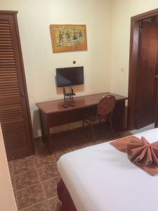 a bedroom with a desk with a computer and a bed at Hotel Clamantis in Yaoundé