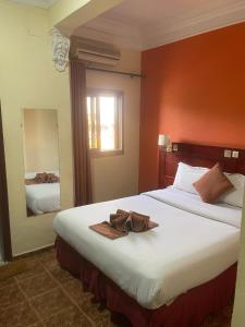 a hotel room with a large bed with a hat on it at Hotel Clamantis in Yaoundé