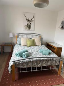 a bedroom with a bed with pillows and a deer picture at 16 Bentley Road - Uttoxeter, Comfortable accommodations, SHARED SHOWER ROOM, NO BREAKFAST in Uttoxeter +13 photos