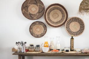 four plates hanging on a wall above a table at O Lugar in Porto Covo