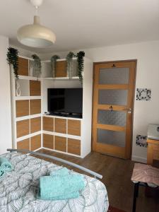 a bedroom with a bed and a television and a door at 16 Bentley Road - Uttoxeter, Comfortable accommodations, SHARED SHOWER ROOM, NO BREAKFAST in Uttoxeter