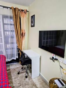 a room with a desk and a television and a chair at The Loft 21 Ngara, Nairobi in Nairobi