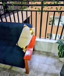 a blue couch with a pillow on a balcony at The Loft 21 Ngara, Nairobi in Nairobi
