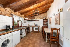 a large kitchen with a table and a laundry room at Casa Miramar in Almogía