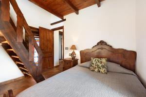 a bedroom with a large bed with a wooden headboard at Casa Miramar in Almogía