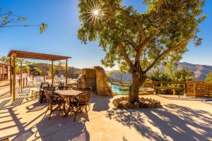 a patio with a table and chairs under a tree at Casa Miramar in Almogía