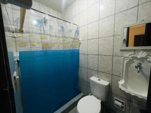 a bathroom with a white toilet and a sink at Morada Coral Hostel em Maracaípe in Porto De Galinhas
