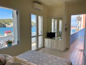 a bedroom with a bed and a balcony with a television at Villa Marisa - La Guarida in Ponza