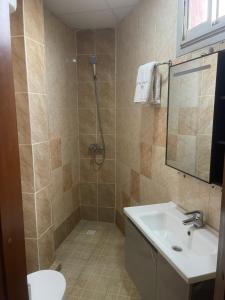 a bathroom with a shower and a sink and a toilet at Hotel Clamantis in Yaoundé +41 photos