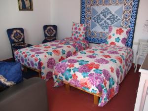 a bedroom with a bed and two chairs at Dar Mozart in Essaouira