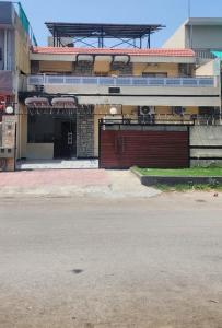 a building with a red door and a garage at New Palace Guest House in Islamabad