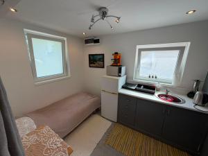 a small kitchen with a bed and a sink at Cozy Studio in Deszk