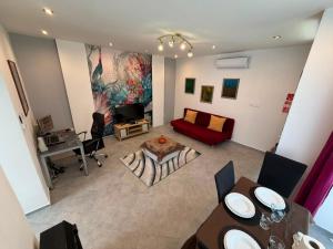 a living room with a red couch and a table at Cozy Studio in Deszk