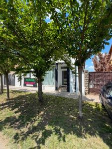 a group of trees in front of a house at Cozy Studio in Deszk