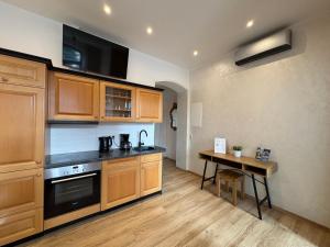 a kitchen with wooden cabinets and a table in it at Ferienwohnungen Landeskrone Dresden in Dresden