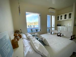 a bedroom with a large bed with a large window at Villa Marisa - La Guarida in Ponza