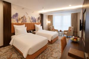 a hotel room with two beds and a desk at TULIP PLAZA - By Le Park Concord in Hafr Al-Batin +25 photos