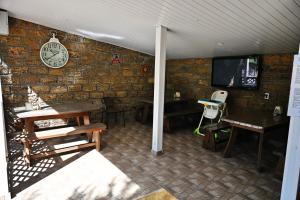 a room with tables and a clock on a brick wall at Hotel-complex Mizh Triokh Ozer in Svityazʼ