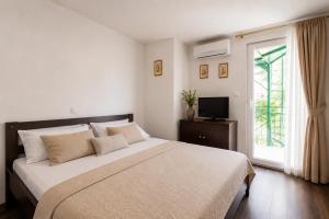 a bedroom with a large bed and a window at Quiet Oasis in the Heart of Old Town- two kitchen,3bath in Split