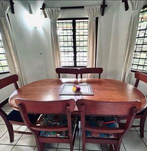 a wooden table with chairs and a plate on it at Beach House - private room in Diani Beach