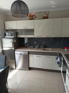 a kitchen with white cabinets and stainless steel appliances at Apartament Kalia in Zamość