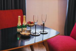 a table with three champagne bottles and a bowl of fruit at Sobe Lotrist in Radovljica