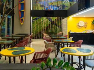 a dining room with yellow tables and chairs at ibis Styles Belem Nazare in Belém