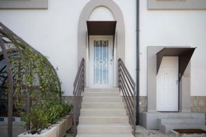 a white building with two doors and stairs at Relais Terramare in Cellole