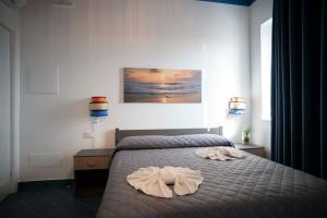 a bedroom with a bed with a robe on it at Relais Terramare in Cellole +150 photos