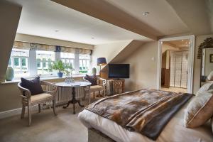 a bedroom with a large bed and a table and chairs at Plough Inn in Lupton
