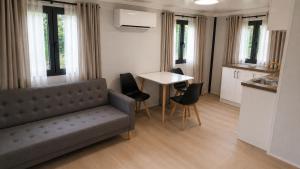 a living room with a couch and a table and chairs at Dīķu oāze in Atspuki