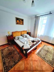 a bed in a room with two rugs on it at Csodarét Kúria in Mórahalom