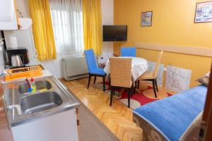a kitchen with a sink and a table with chairs at Apartment Bojke in Niš