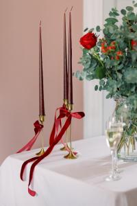 two candles on a table with flowers and wine glasses at The Station House Hotel in Kilmessan