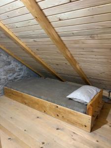 a wooden bed in a attic with a wooden ceiling at Košara Trišnjevac in Lusnić