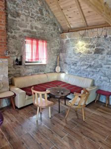 a living room with a couch and a table and chairs at Košara Trišnjevac in Lusnić +19 photos