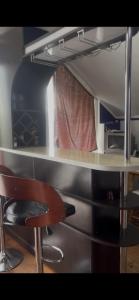 a desk with a chair next to a counter top at ძველი სახლი Old house in Ureki