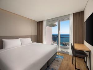 a bedroom with a bed and a desk and a window at Wyndham Goseong Gangwon Hotel in Goseong