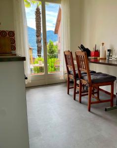 a kitchen with two chairs and a counter with a window at Pensione Solaria in Locarno