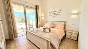 a bedroom with a bed and a large window at Il Soffione in Castelsardo