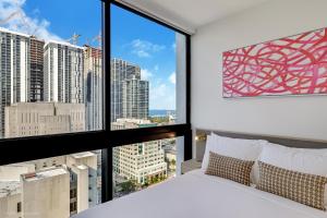 a bedroom with a bed and a large window at District 225 Condo by Ionica in Miami +291 photos
